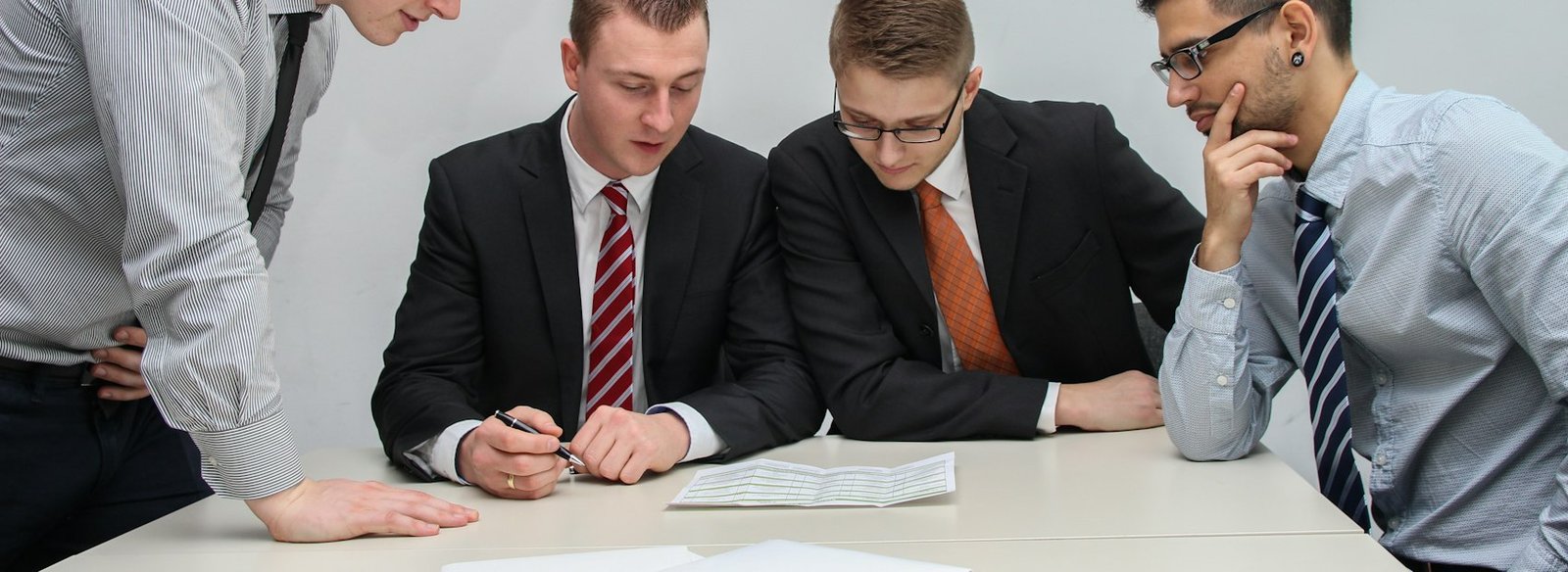 A hiring team working through papers around a table