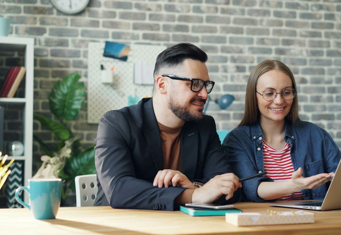Two colleagues talking at a desk