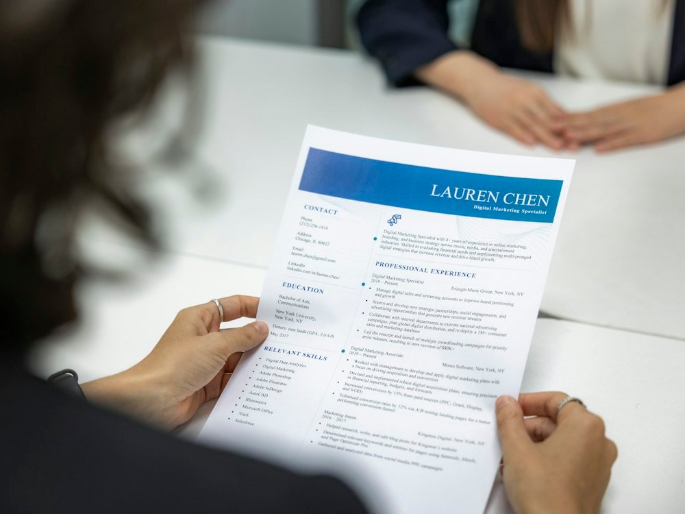 Someone reading a resume across a table in an interview