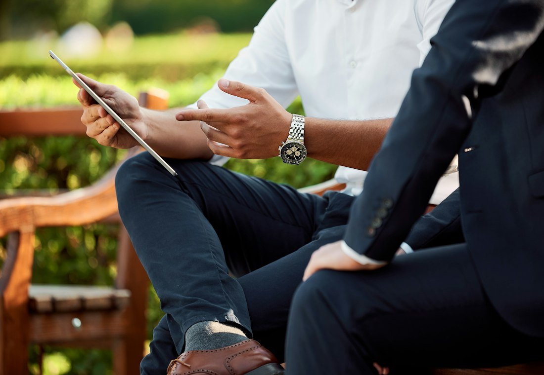 Two people talking over a tablet